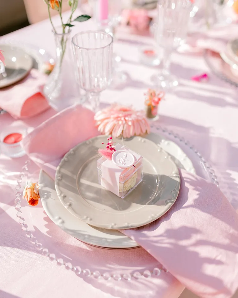 Pink-themed table setting with flowers and elegant dishware
