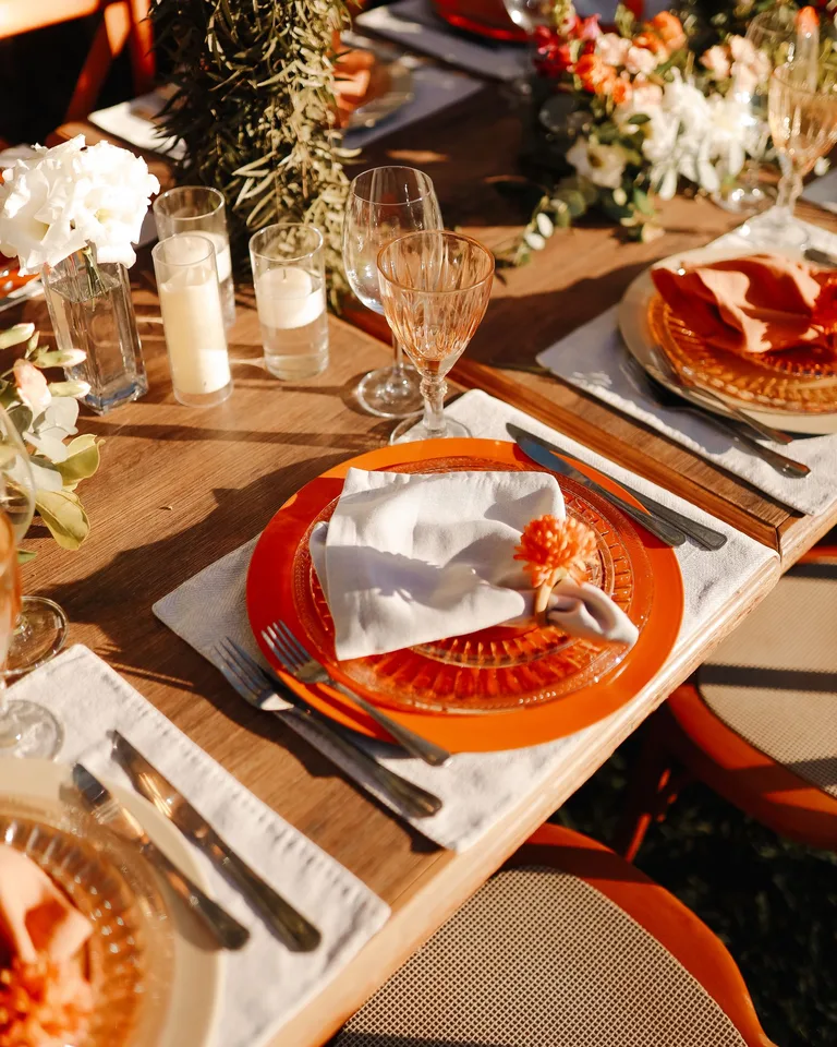 Beautiful outdoor dining setup with elegant tableware and floral decor at sunset