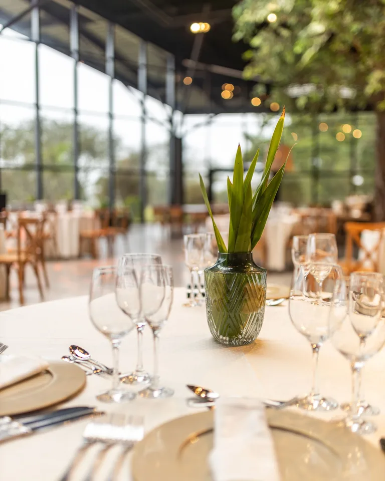 Crystal vase with green leaves on a restaurant table