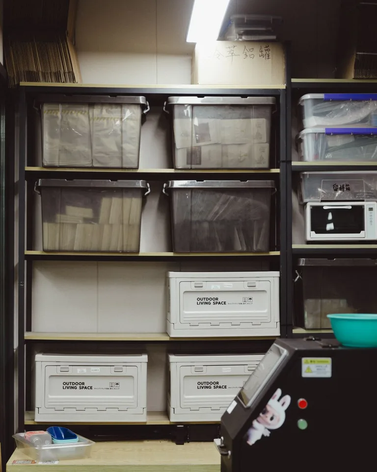 Neatly organized storage room with labeled plastic containers on shelves